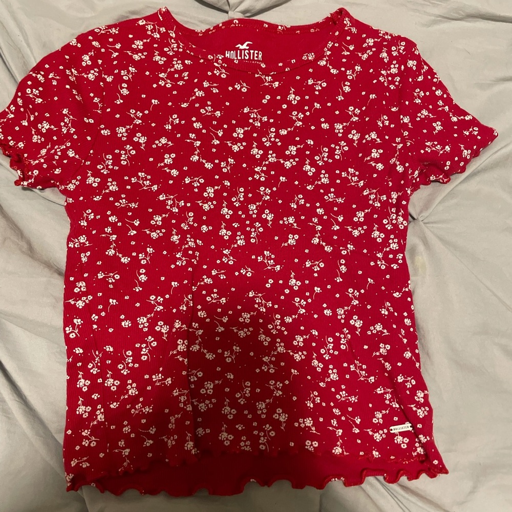 red top with white flowers,ruffles at bottom and at sleeves